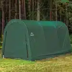 Skladiščni šotor Maxy dimenzij 3m x 46m postavljen v gozdnem okolju ki prikazuje njegovo trajnost in primeren zunanji videz za shranjevanje opreme na prostem