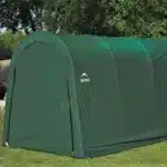 Zaprta podoba skladiščnega šotora Maxy z dimenzijami 365 m x 610 m postavljenega na zelenici ki prikazuje trpežno zeleno prevleko in značilno obliko za zaščito opreme