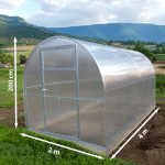 Arched translucent greenhouse with a metal frame in a rural field base measures 2 m by 4 m and height 2 m 200 cm