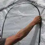 Detajl odprtega vhoda v rastlinjak Maxy Grow 37 x 61 m ki prikazuje trpežno zasnovo in lahko dostopnost za vrtnarjenje in shranjevanje