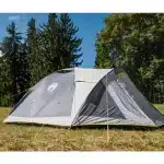 Šotor Coleman Darwin 3+ postavljen na travniku v gozdnatem okolju pripravljen za kampiranje v naravi