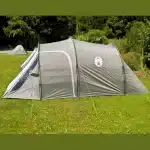 Šotor Coleman Coastline 3+ postavljen na zeleni travi z naravnim okoljem v ozadju