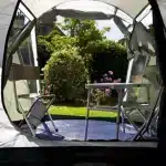 Notranji pogled šotora Coleman Coastline 3+ s pogledom na vhod in opremljen z mizico in stoli