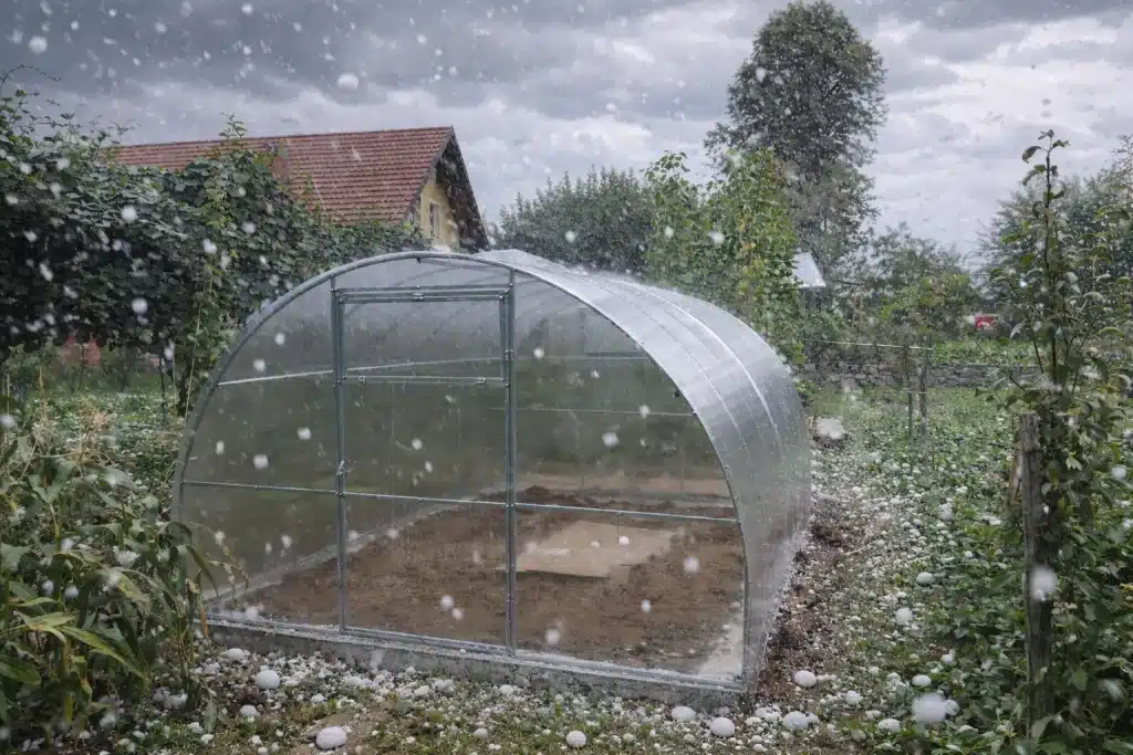 polikarbonatnirastlinjakiodporninatoco MaxyHomesi Polikarbonatni rastlinjak MaxyHome med močnim neurjem s točo ki prikazuje izjemno odpornost konstrukcije in kritine na udarce