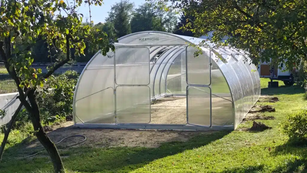 vrtnirastlinjakimaxyhomeslovenija MaxyHomesi Prostoren polikarbonatni rastlinjak MaxyHome z ločnimi vrati postavljen na sončni lokaciji na urejenem vrtu Idealna rešitev za podaljšanje rastne sezone