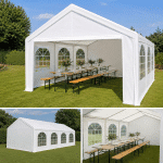 White event tent on a green lawn with long wooden tables benches and floral centerpieces inside and arched window walls