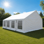 Large white event tent set up on a grassy field under a bright sun with clear windows along the side and red rope ties securing it