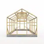 Wooden house framing structure on a concrete foundation showing wall studs and pitched roof trusses